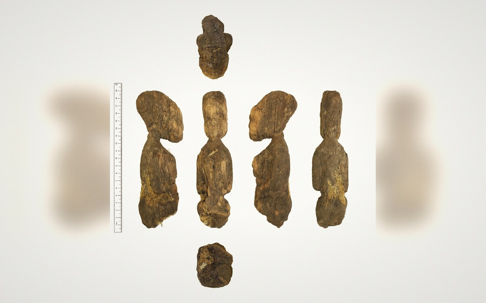 A carved wooden figurine shown from multiple angles beside a measuring scale